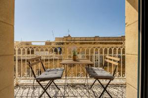 a patio with a table and chairs on a balcony at 23 Boutique Hotel in Il-Furjana