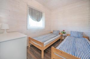 a room with two beds and a window at Domki PoZdrowie in Rusinowo