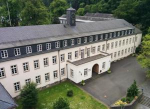 an overhead view of a large white building with a clock tower at Gastflügel der Abtei Maria Laach in Glees