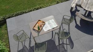 a table and four chairs on a patio at "Petite perle en Haute Ardenne" avec vue sur la vallée, cabine infra-rouge et bain balnéo in Lierneux