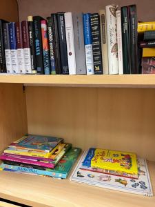 two books are sitting on a book shelf at Hotel Tikkurila in Vantaa