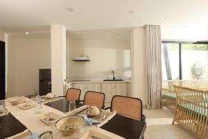 a dining room with a table and chairs and a kitchen at Cham Riverside in Thôn Xuân Lạc
