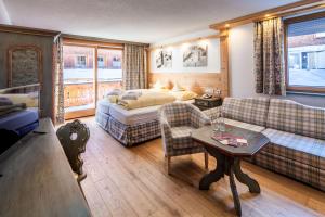a hotel room with a bed and a couch at Hotel Anemone in Lech am Arlberg
