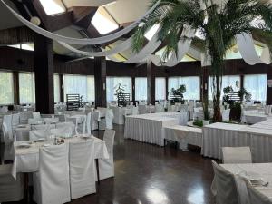 a banquet hall with white tables and white chairs at Vila Milka in Lepterija