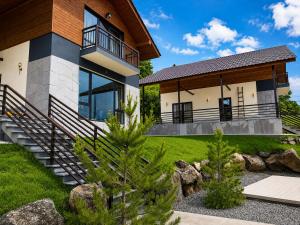 a house with a staircase leading to the front yard at Crown Villa Bakuriani in Bakuriani