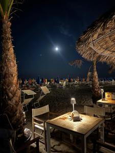 a table and chairs on the beach at night at Open space centre in Lignano Sabbiadoro