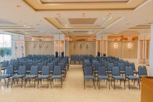 an empty hall with chairs and a podium in a room at Hotel Rangoli - 10 min from Palsana chowk in Navsāri