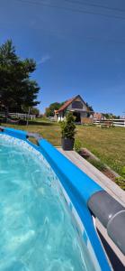 a swimming pool with blue water in a yard at W ładnym polu n1 in Ruciane-Nida
