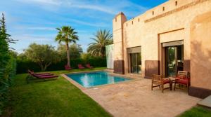 a swimming pool in the yard of a house at Villa AG Marrakech in Marrakesh