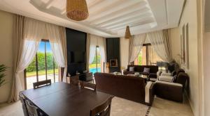 a living room with a table and chairs and a couch at Villa AG Marrakech in Marrakesh