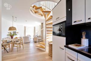 a kitchen and dining room with a spiral stairway at Haus Nordstrand in Norderney
