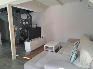 a living room with a couch and a tv at Hamabi in Hendaye