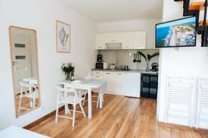 a kitchen with white cabinets and a table and chairs at Domki Wierzbówka- Basen, Sauna, Rowery in Mielno