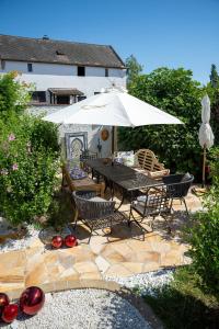 a patio with a table and chairs and an umbrella at Haus Diogenes in Mörbisch am See