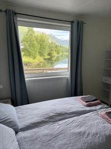 a bedroom with a window with a view of a lake at House on the lake in Bogen