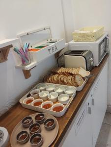 a counter with trays of food and a microwave at Hotel Lobo de Mar in Mar del Plata