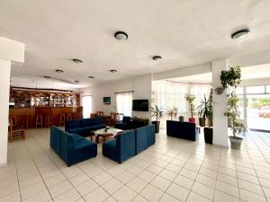 a living room with blue couches and a table at Achillion Hotel in Skala Potamias
