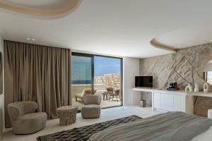a bedroom with a king sized bed and a living room at Tagoo Hills in Mikonos
