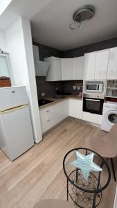 a kitchen with white cabinets and a starfish on a table at CORNELIAS HOME 1A between LAS VISTAS & LOS CRISTIANOS BEACH in Los Cristianos +3 photos