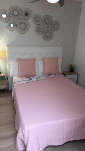 a pink bed with pink pillows in a bedroom at CORNELIAS HOME 1A between LAS VISTAS & LOS CRISTIANOS BEACH in Los Cristianos