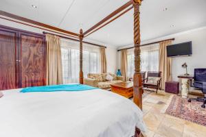 a bedroom with a large bed and a living room at 42onKing in Centurion