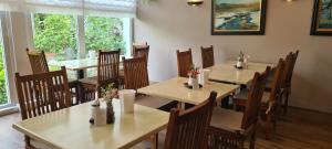 a restaurant with wooden tables and chairs with flowers on them at Hotel Wörth in Wörth an der Isar +20 photos