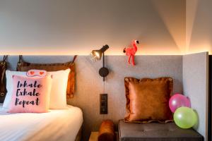 a bedroom with a bed with a pillow and balloons at Moxy Bordeaux in Bordeaux +76 photos