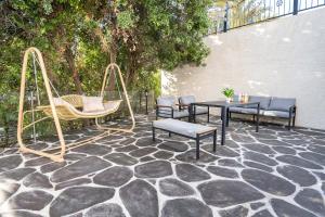 a patio with chairs and a table and swings at כתר הגליל - ווילה יוקרתית עם 4 סוויטות ובריכה מפנקת in ‘Ein el Asad