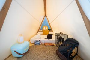 a room with a tent with a bed and a suitcase at Kampaoh Hostel Trafalgar in Los Caños de Meca +24 photos
