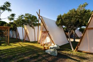 a row of tents sitting in the grass at Kampaoh Hostel Trafalgar in Los Caños de Meca