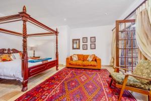 a bedroom with a canopy bed and a couch at 42onKing in Centurion