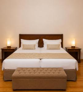 a bedroom with a bed with a ottoman and two lamps at Capsis Bristol Boutique Hotel in Thessaloniki