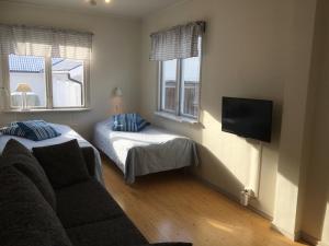 a living room with a couch and a bed and window at Lilla Skottek in Ulricehamn