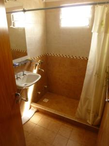 y baño con ducha y lavamanos. en Posada del Lago en Villa Carlos Paz