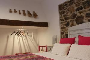 a bedroom with a bed with red and white pillows at Monte de Portugal in Montargil +64 photos