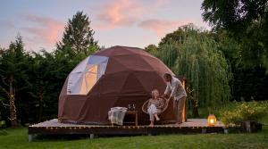 a man and woman standing in front of a tent at Little Wood Lodges in Bailly-aux-Forges