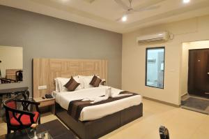 a bedroom with a bed and a chair and a window at Hotel EVA in Chandīgarh