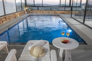 a swimming pool with a table and glasses of wine at כתר הגליל - ווילה יוקרתית עם 4 סוויטות ובריכה מפנקת in ‘Ein el Asad +33 photos