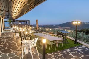 a patio with tables and chairs and lights at כתר הגליל - ווילה יוקרתית עם 4 סוויטות ובריכה מפנקת in ‘Ein el Asad