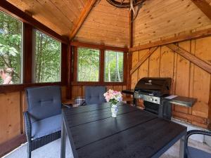 a wooden cabin with a table and chairs and a stove at Drevenica U Bučkov in Lutiše