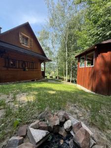 a log cabin with a fire pit in front of a yard at Drevenica U Bučkov in Lutiše
