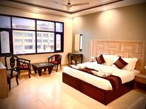 a bedroom with a bed and a table and a window at Hotel EVA in Chandīgarh
