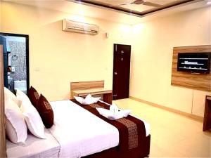 a bedroom with a bed with white sheets and pillows at Hotel EVA in Chandīgarh