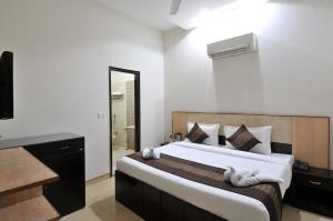 a bedroom with a large bed and a bathroom at Hotel EVA in Chandīgarh