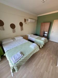 two beds in a room with green walls and wooden floors at Mavi Kuş in Bektaş