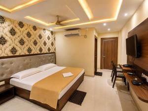 a bedroom with a bed and a desk and a television at Hotel Baikuntha International Puri Near Sea Beach With Parking AC Or Non AC Both Room in Puri