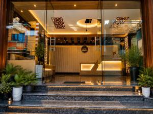 a lobby of a building with stairs and plants at Hotel Baikuntha International Puri Near Sea Beach With Parking AC Or Non AC Both Room in Puri
