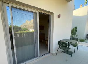 a balcony with a table and chairs and a sliding glass door at MIRA MARE - Apartments 1 & 8 in Stavros
