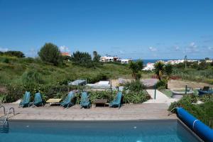 a group of chairs and a swimming pool at WOT Ericeira Surf Social in Ericeira