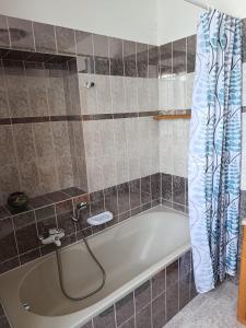 a bath tub with a hose in a bathroom at Locazione breve LE ROSE in Darfo +10 photos